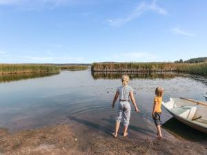 dos niños parados en el agua junto a un barco en Holiday Home C by Interhome en Porvoo