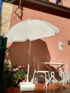 a white umbrella sitting next to a table and chairs at Ca' di Ro in Camogli