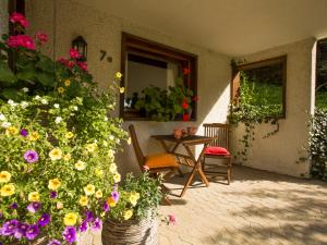 eine Terrasse mit Blumen, einem Tisch und einem Stuhl in der Unterkunft Apartment Reinskopf-1 by Interhome in Schönecken