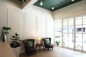 金三角Buakham Rim Khong บัวคำริมโขง的一间设有两把椅子和一张带台灯的桌子的房间