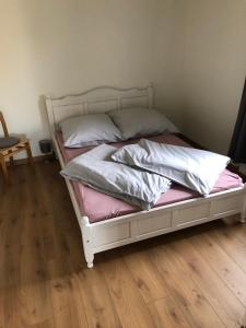 een wit bed met kussens in een kamer bij Heckenstübchen in Simmerath