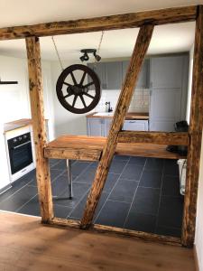 a kitchen with a table and a wheel hanging from the ceiling at Heckenstübchen in Simmerath