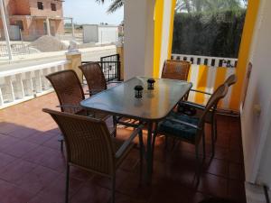 Luxury and comfort in La Marina, with sea views at El Pinet beach في لا مارينا: طاولة وكراسي على شرفة مع طاولة ونافذة