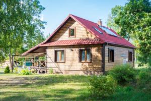 a small wooden house with a red roof at Agroturystyka Żubr in Siemianówka