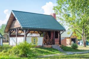 une maison avec un toit métallique et un garage dans l'établissement Agroturystyka Żubr, à Siemianówka