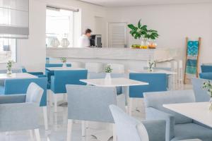 a restaurant with blue and white tables and chairs at Nissi Park Hotel in Ayia Napa