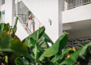 a woman in a hat walking down a staircase at Nissi Park Hotel in Ayia Napa