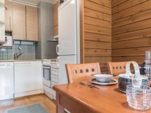 a kitchen with a wooden table with two chairs at Holiday Home Ylläs chalets a507 by Interhome in Ylläsjärvi