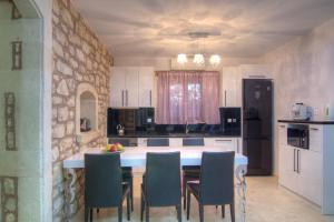 a kitchen with a table with chairs and a counter top at Green Paradise Villa in Margarítai