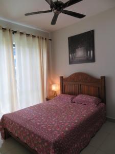 a bedroom with a bed and a ceiling fan at MSI Cozy Homestay in Seri Kembangan