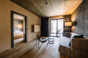 sala de estar con sofá y dormitorio en Panoramic Suites Winzerhöhe, en Scena