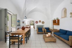 un soggiorno con un tavolo e un divano blu di Masseria Villa by Perle di Puglia a Torre Specchia Ruggeri