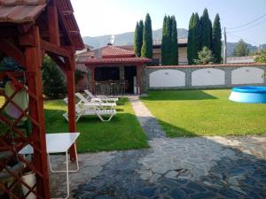 a yard with white chairs and a blue frisbee at Riverside Villa Matka in Skopje