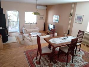 a living room with a table and chairs and a couch at Riverside Villa Matka in Skopje