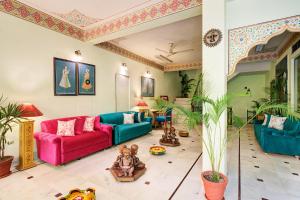 a living room with a red and blue couch at Hotel Sarang Palace - Boutique Stays in Jaipur