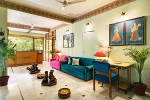 a living room with a blue couch and a table at Hotel Sarang Palace - Boutique Stays in Jaipur