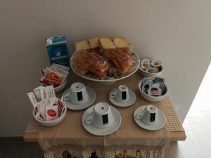 einen Tisch mit Teller und Schalen mit Lebensmitteln in der Unterkunft B&B Sweet Home in Grumo Appula
