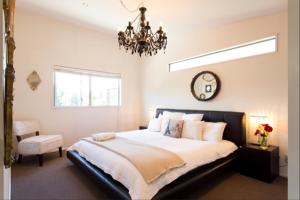 a bedroom with a large bed and a chandelier at Treehouse Spa Escape - Private Spa Pool in Queenstown