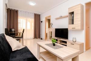 a living room with a couch and a tv and a table at Espanatour TORREMAR in La Mata