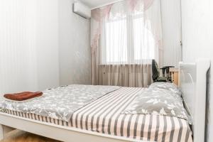- une chambre blanche avec un lit et une fenêtre dans l'établissement Fransuaza Apartments, à Odessa