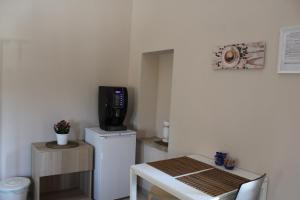 um pequeno quarto com uma televisão e um pequeno frigorífico em Archi Rooms em Loreto