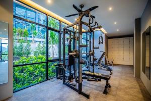 a gym with a treadmill and a elliptical trainer at The Woods Natural Park Resort Phuket in Kamala Beach