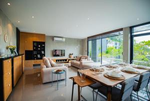 a kitchen and living room with a table and chairs at The Woods Natural Park Resort Phuket in Kamala Beach