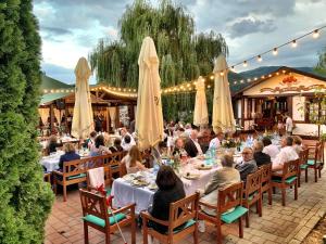 a group of people sitting at tables at a restaurant at Pensiunea Apfelhaus in Cisnădioara