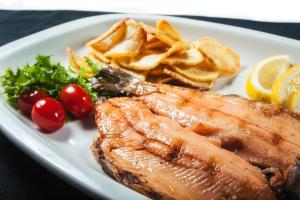 a plate of food with fish and chips and vegetables at Hotel de la Cañada in Córdoba