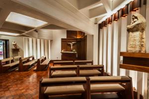 a row of chairs in a waiting room with a statue at Hotel de la Cañada in Córdoba