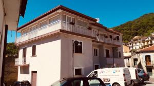 un edificio bianco con balcone sopra di Tempio Aurora a San Costantino Albanese