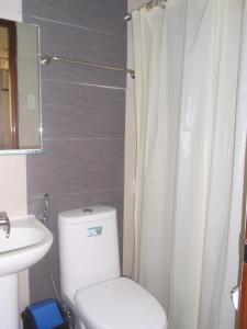 a bathroom with a white toilet and a sink at ZIUR INN in Laoag +30 photos