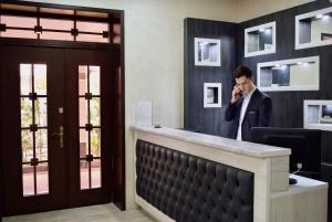 a man talking on a cell phone in an office at Dostar Inn in Shymkent