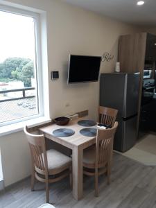 uma cozinha com uma mesa e cadeiras e um frigorífico em Apartment RELAX em Ruse