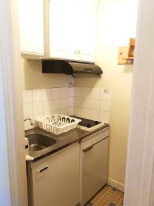 a small kitchen with a sink and a stove at Studio Résidence le Metropole in La Bourboule +8 photos