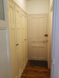 un pasillo con armarios blancos y una puerta blanca en Studio Résidence le Metropole, en La Bourboule