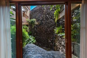 a window view of a stone wall and a staircase at Hotel de la Cañada in Córdoba