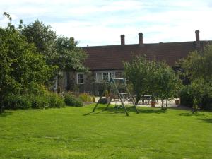 a swing set in the yard of a house at Blue Bell Hotel in Belford