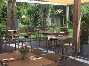 een groep tafels en stoelen op een patio bij Hotel du parc in Vergt