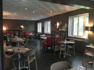 a restaurant with tables and chairs in a room at Hotel du parc in Vergt