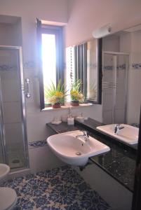 a bathroom with a sink and a shower and a toilet at B&B Il Resort Dell'Artista in Venetico