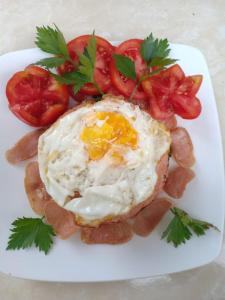 a fried egg and tomatoes on a white plate at Karta House in Ubud +7 photos