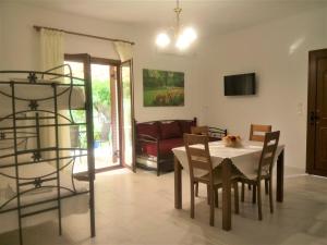 een eetkamer en een woonkamer met een tafel en stoelen bij Grammatoula Apartment in Nikiana
