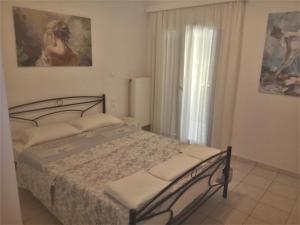 a bedroom with a bed and a window at Grammatoula Apartment in Nikiana