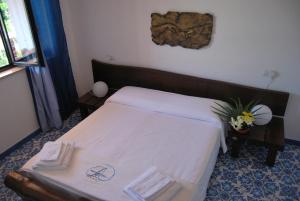 a small bedroom with a bed with white sheets at B&B Il Resort Dell'Artista in Venetico