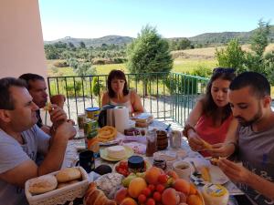 a group of people sitting around a table eating food at Belmonte - Solar Rubina - Piscina água salgada in Belmonte