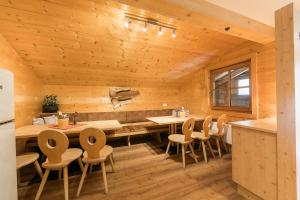 Cabaña de madera con cocina con mesa y sillas en Balbach Alm Apartment, en Oetz