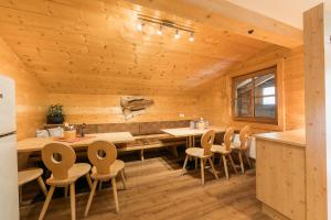 a log cabin kitchen with a table and chairs at Balbach Alm Apartment in Oetz