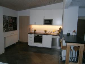 a kitchen with white cabinets and a sink and a counter at Wohnen im ehemaligen Kaminstudio mit Klimaanlage in Lutherstadt Wittenberg