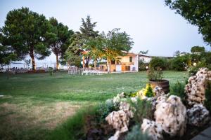 un patio con una casa con mesas y flores en Kokkinos, en Vourvourou